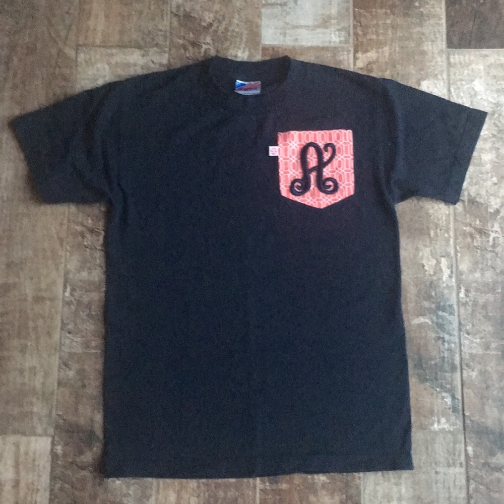 Navy blue, size small tee with “A” on pocket